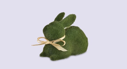 A green Amscan Easter Moss Laying Bunny Decoration