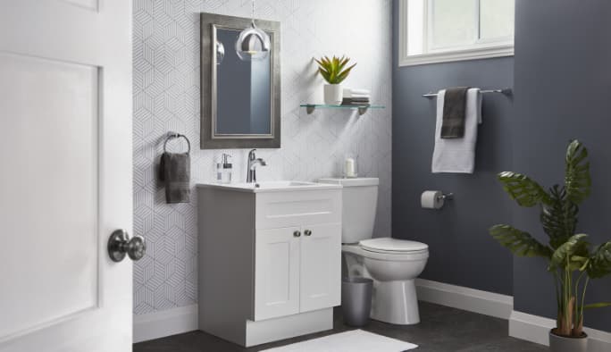 Une salle de bain en blanc et gris avec toilettes, meuble-lavabo,  étagères flottantes et d'autres articles de la collection Milford de CANVAS.