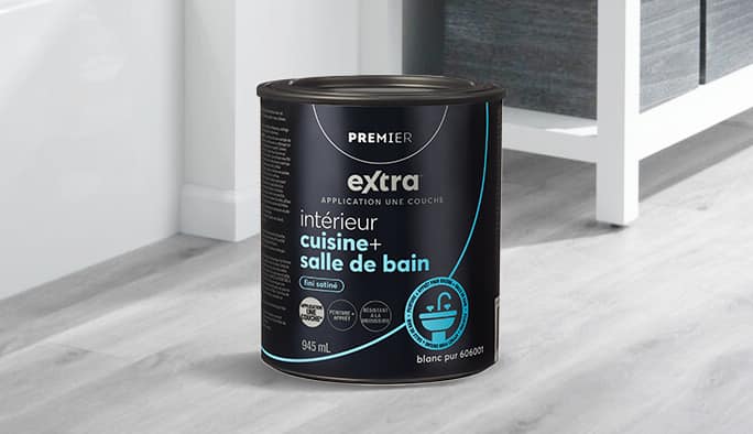 Un pot de peinture Premier Interio Kitchen & Bath reposant sur un plancher en bois dur.