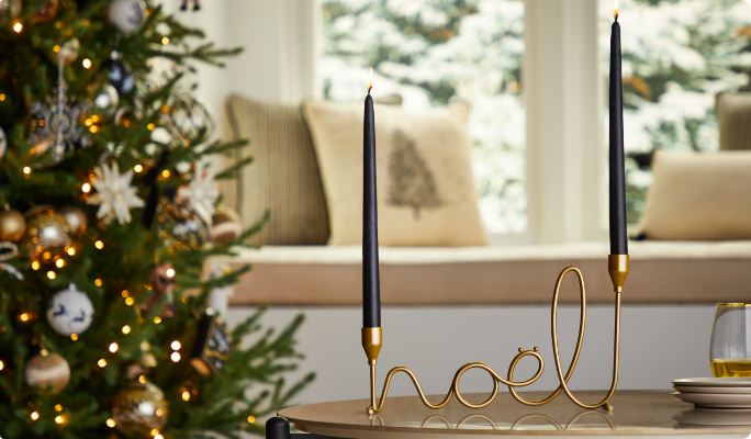 Un porte-bougie conique en laiton CANVAS Noël sur une table dans un salon.