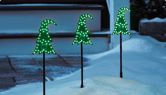 3 Crumpit Tree Stake Lights in a snowy yard.