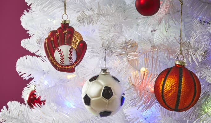 CANVAS Glass Sports Ornaments hung on a white Christmas tree. 