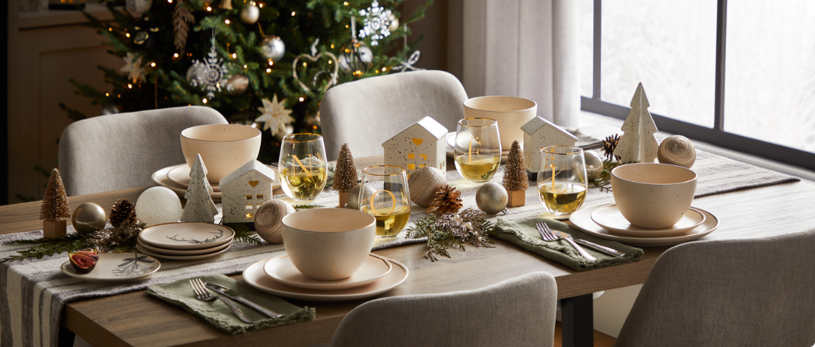 A dining table with CANVAS Night Before Christmas tableware and decor. 