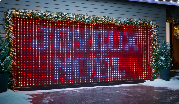 Un garage décoré de rideaux lumineux sur lesquels on peut lire «Merry Christmas ».