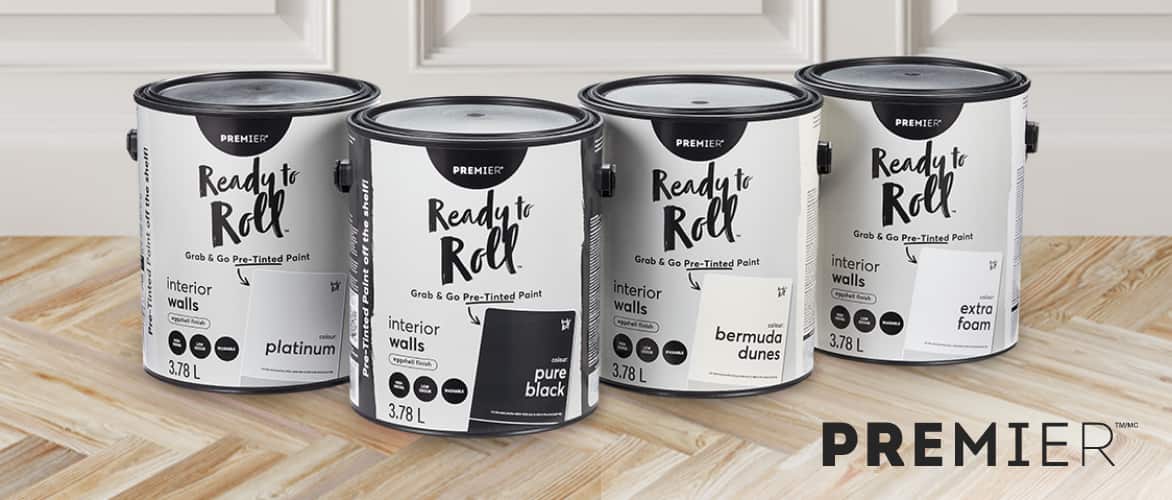 Four assorted 3.78-L cans of Premier Ready to Roll Paint on a hardwood floor.