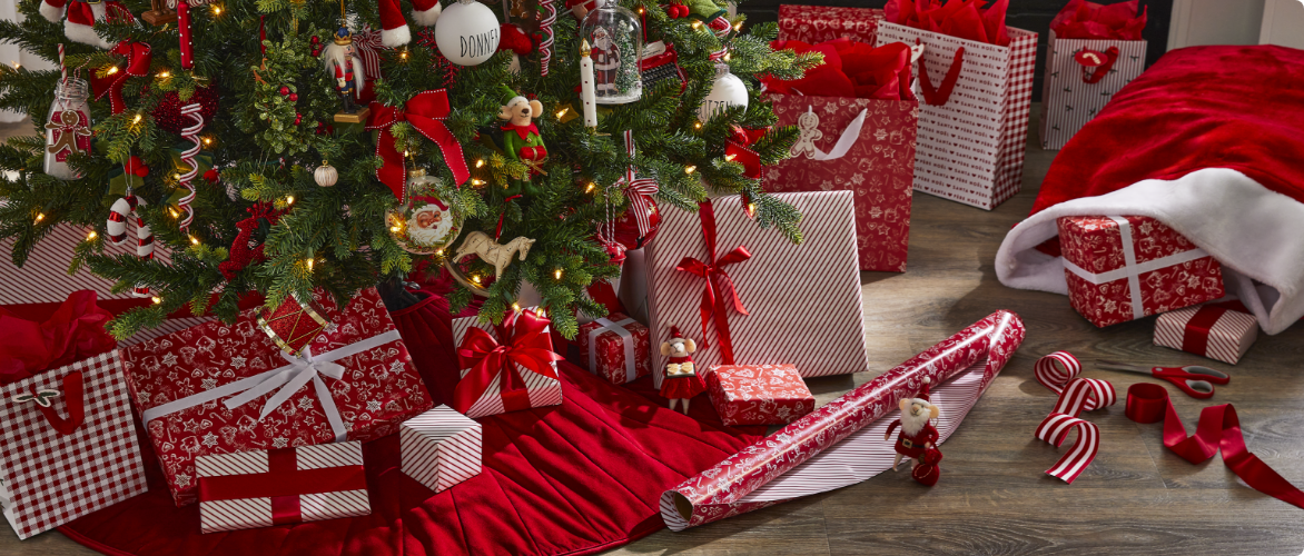 Rouleaux de papier cadeau CANVAS et cadeaux emballés sous un sapin.