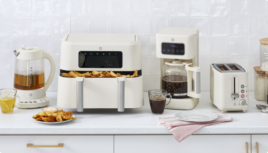 A set of various matching soft beige-coloured kitchen appliances.