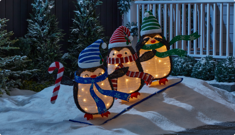 Ensemble de 3 pingouins skieurs pliants à DEL CANVAS dans une cour enneigée.