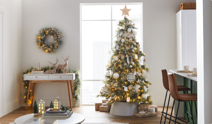 A living room with a Christmas tree and CANVAS White Christmas decorations.