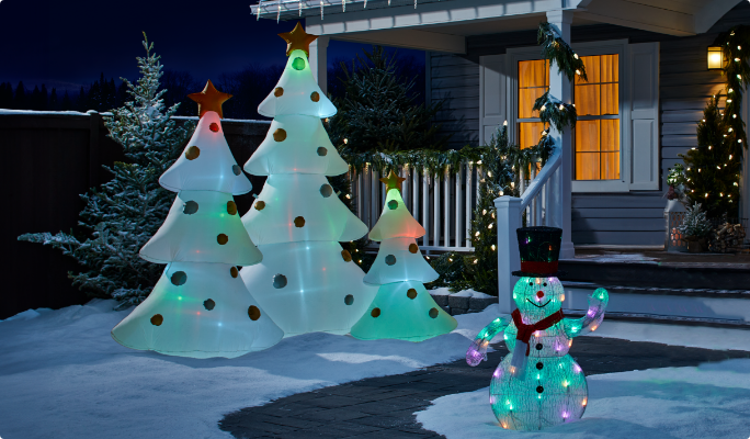 NOMA Advanced Smart 2.0 pre-lit inflatable decorations in a snowy yard. 