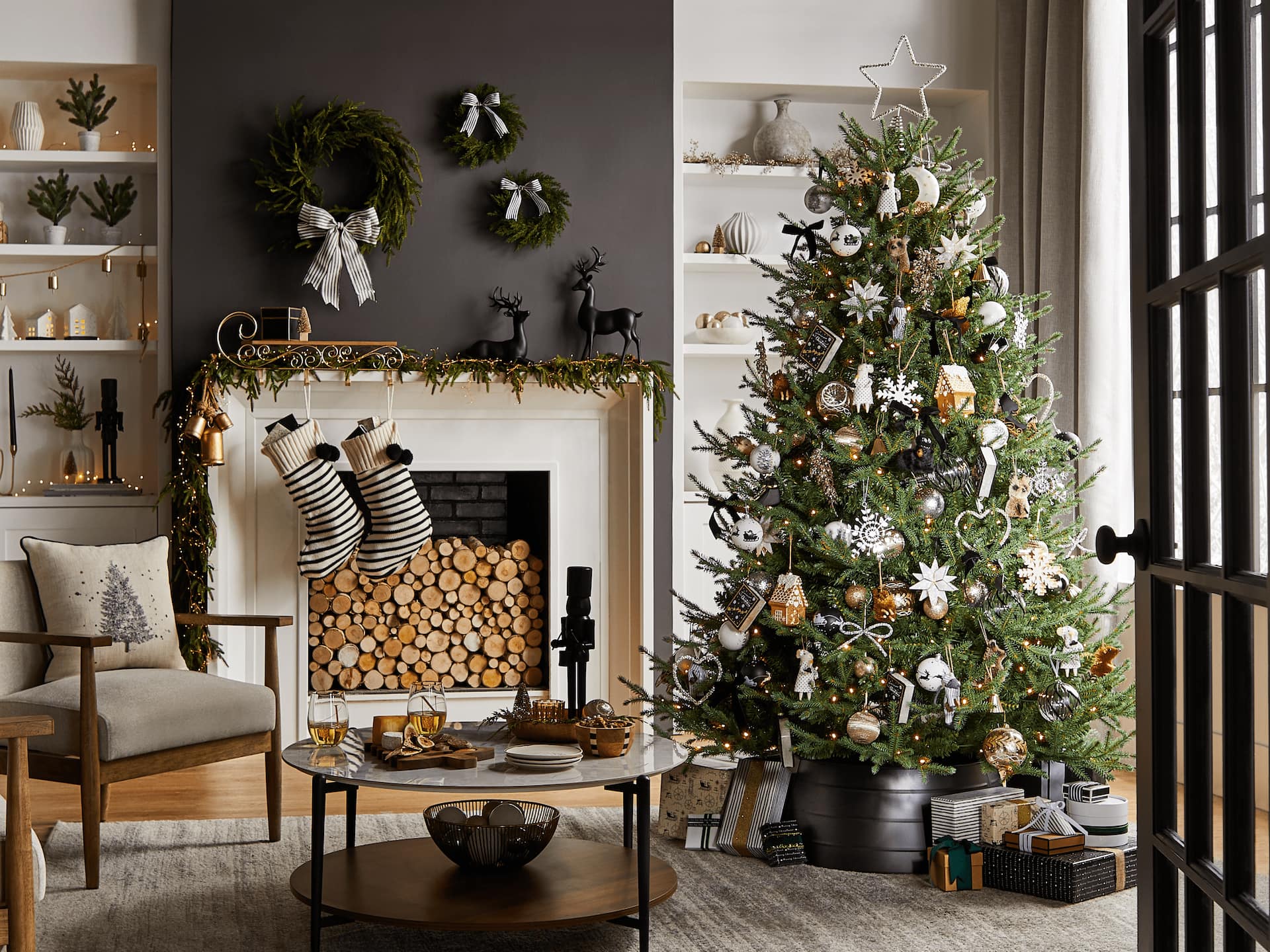 A living room with a Christmas tree and black, white and gold CANVAS Night Before Christmas decorations.