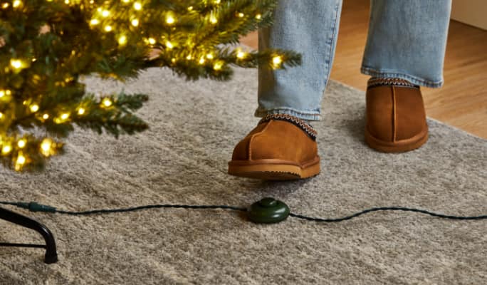 Un adulte utilise la pédale pour alimenter un arbre scintillant pré-éclairé NOMA Taylor .