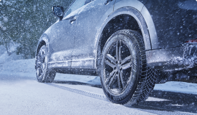 A car on a snowy road with MotoMaster Winter Edge II tires. 