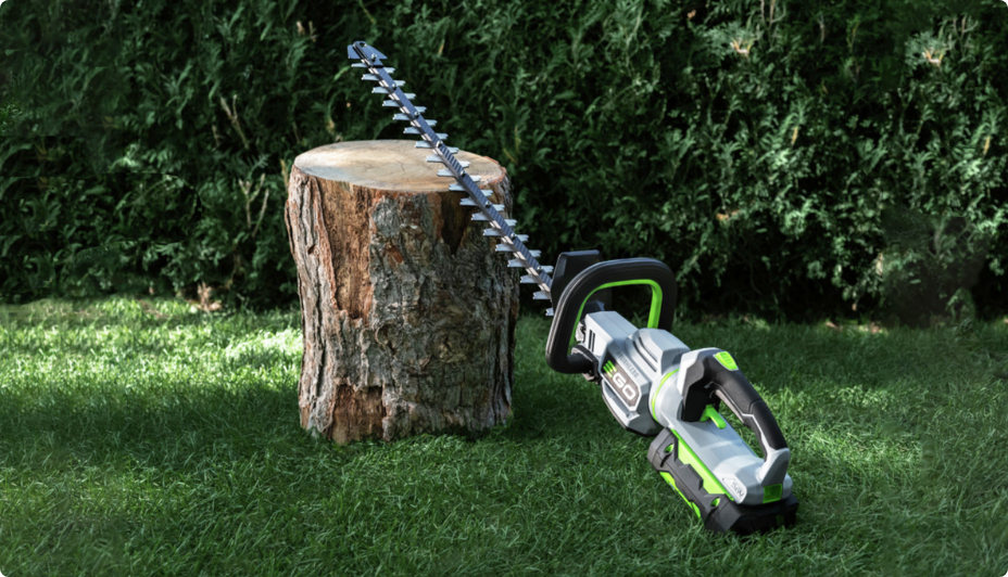 An EGO Hedge Trimmer resting against a tree stump.