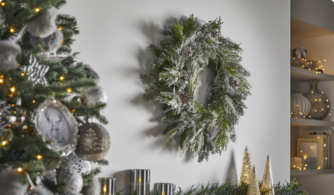 CANVAS Flocked Cedar Wreath hanging on a wall in a living room. 