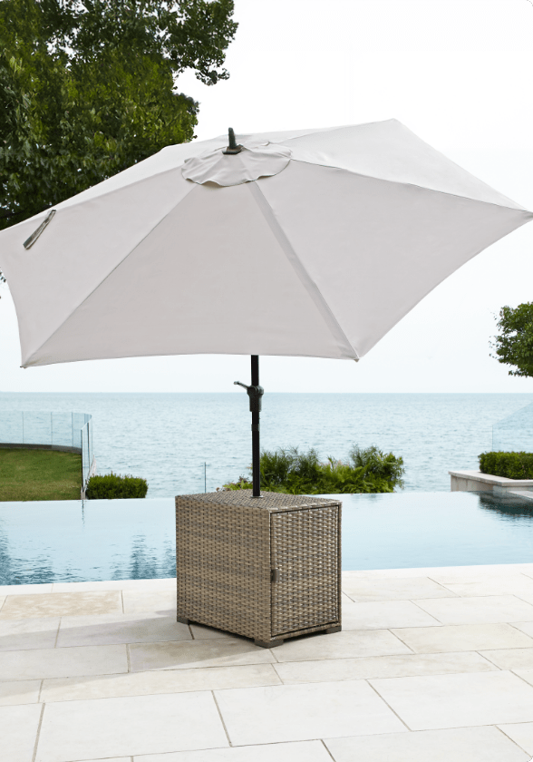 CANVAS Bala Patio Umbrella Table set up on a poolside patio with a grey umbrella.