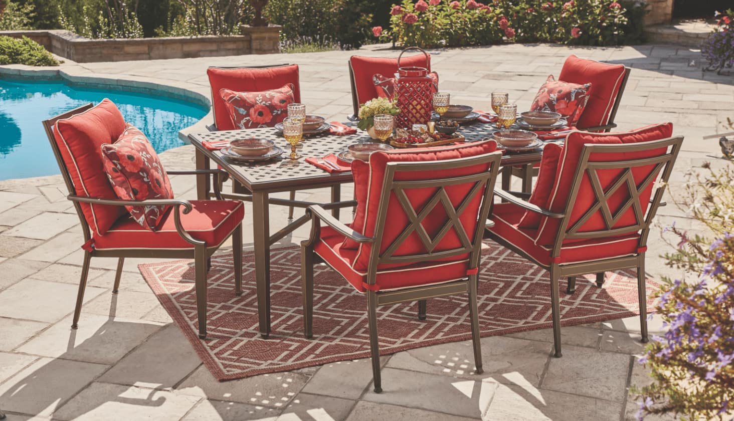 A CANVAS Coventry Hills Collection dining table and six cushioned dining chairs on a poolside patio.