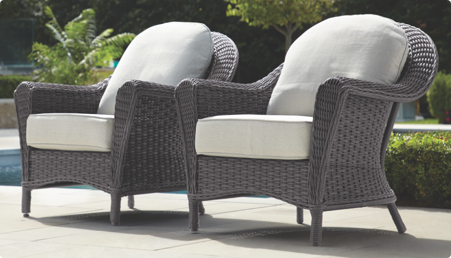  Two wicker CANVAS Summerhill Armchairs side by side on a poolside patio. 