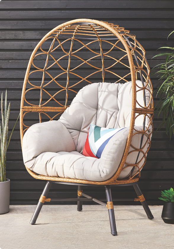 Fauteuil ovoïde CANVAS Sydney avec coussins sur une terrasse. 