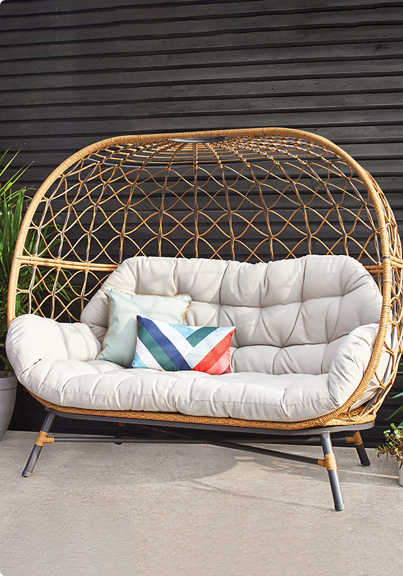 Fauteuil ovoïde double CANVAS Sydney avec coussins sur une terrasse. 