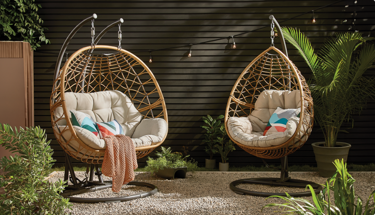 Two CANVAS Sydney Egg swing chairs on a backyard patio.