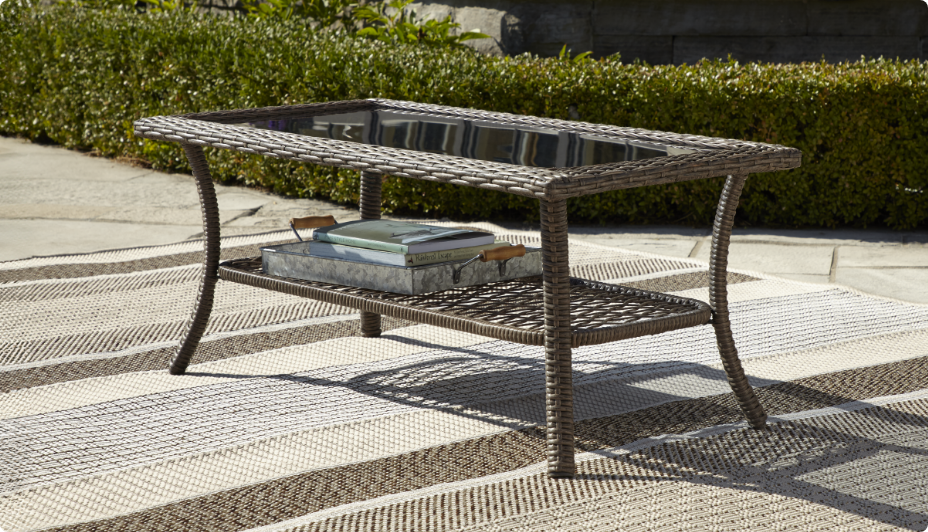 The CANVAS Canterbury Coffee Table in front of a grassy hedge.