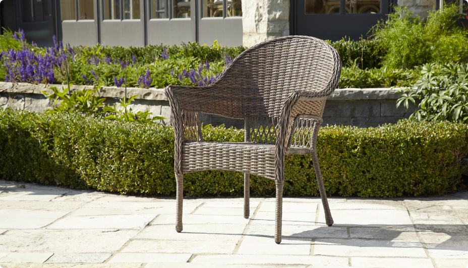 The CANVAS Canterbury Armchair in front of a grassy hedge. 