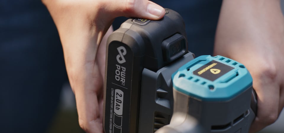Une personne qui met une batterie PWR POD 2,0 Ah dans un outil Yardworks.
