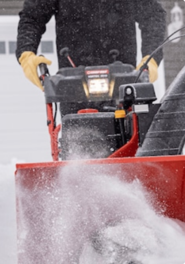 A Yardworks 224 CC Snowblower clearing snow from a sidewalk.