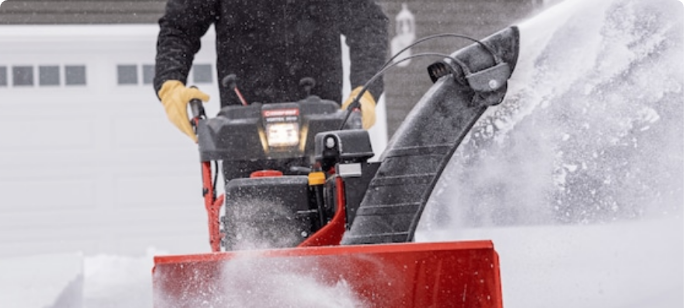 A Yardworks 224 CC Snowblower clearing snow from a sidewalk.