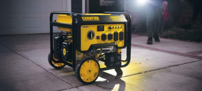 A generator on a driveway with a flashlight glow coming from behind.