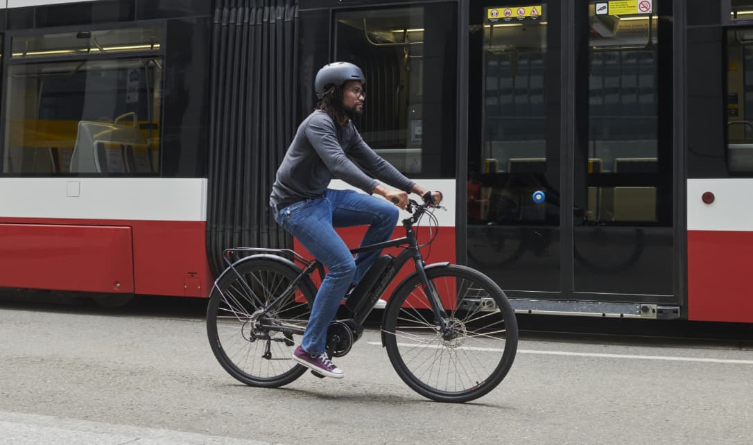 A woman riding an e-bike with pedal assist on a downtown Toronto street. 