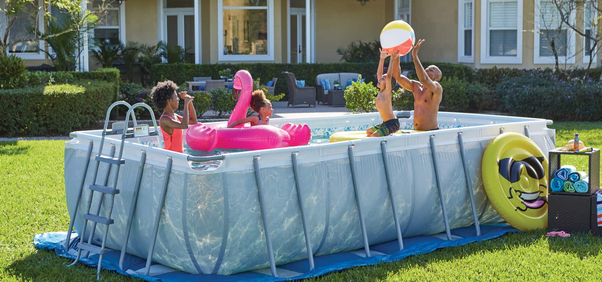 An adult and three kids swimming and playing in a Coleman Steel Frame Pool in a backyard. 