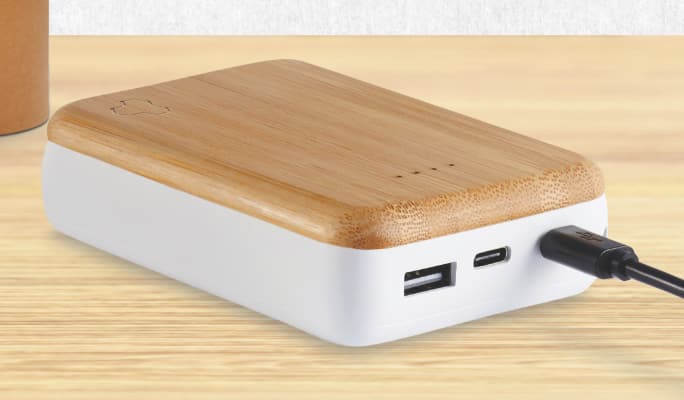 A Bluehive 10K mAh Wood Power Bank on a wood surface.