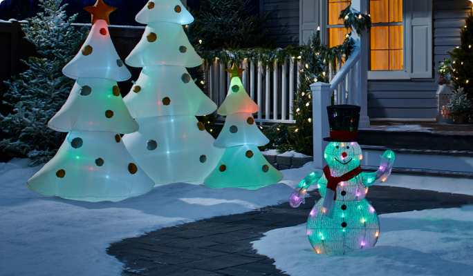 A set of inflatable Christmas trees with lights and a wire form snowman with lights.