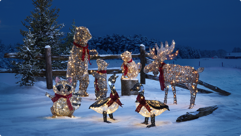 Assortment of CANVAS Canadian Cabin pre-lit Christmas wireforms on snowy lawn