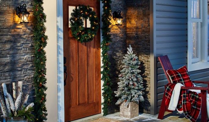 Assorted Christmas decorations, garlands and wreaths on front porch.