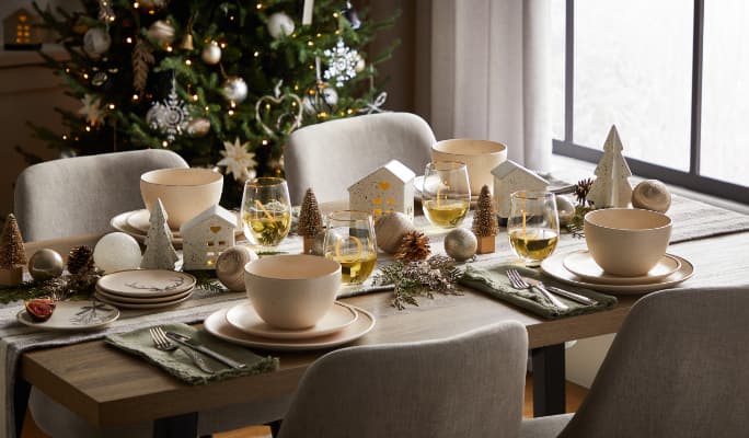 A dining table with CANVAS Night Before Christmas dinnerware and decor.