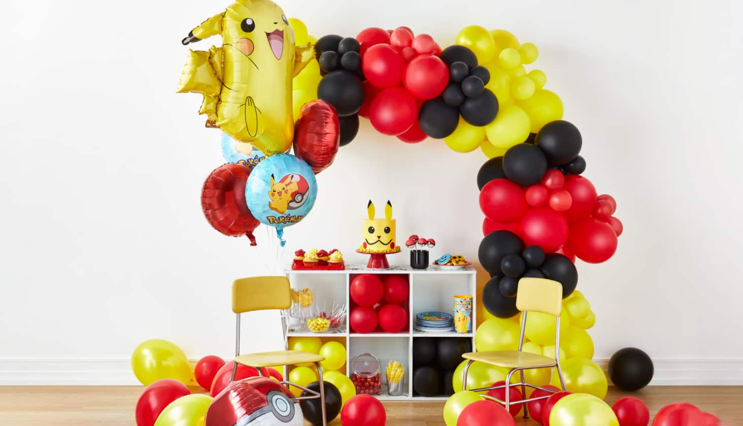 A Pokémon themed balloon arch and various Pokémon tabletop decor.