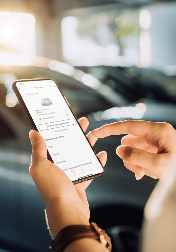 Une personne utilisant une appli de téléphone intelligent pour vérifier les données de sa voiture.
