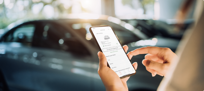 Une personne utilisant une appli de téléphone intelligent pour vérifier les données de sa voiture.