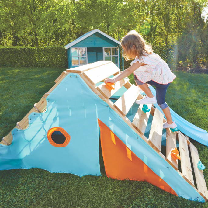 A child climbs on a Plum outdoor play centre.