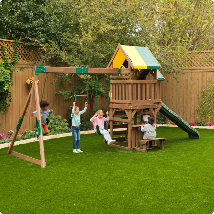 A wooden playset with swings and a slide.