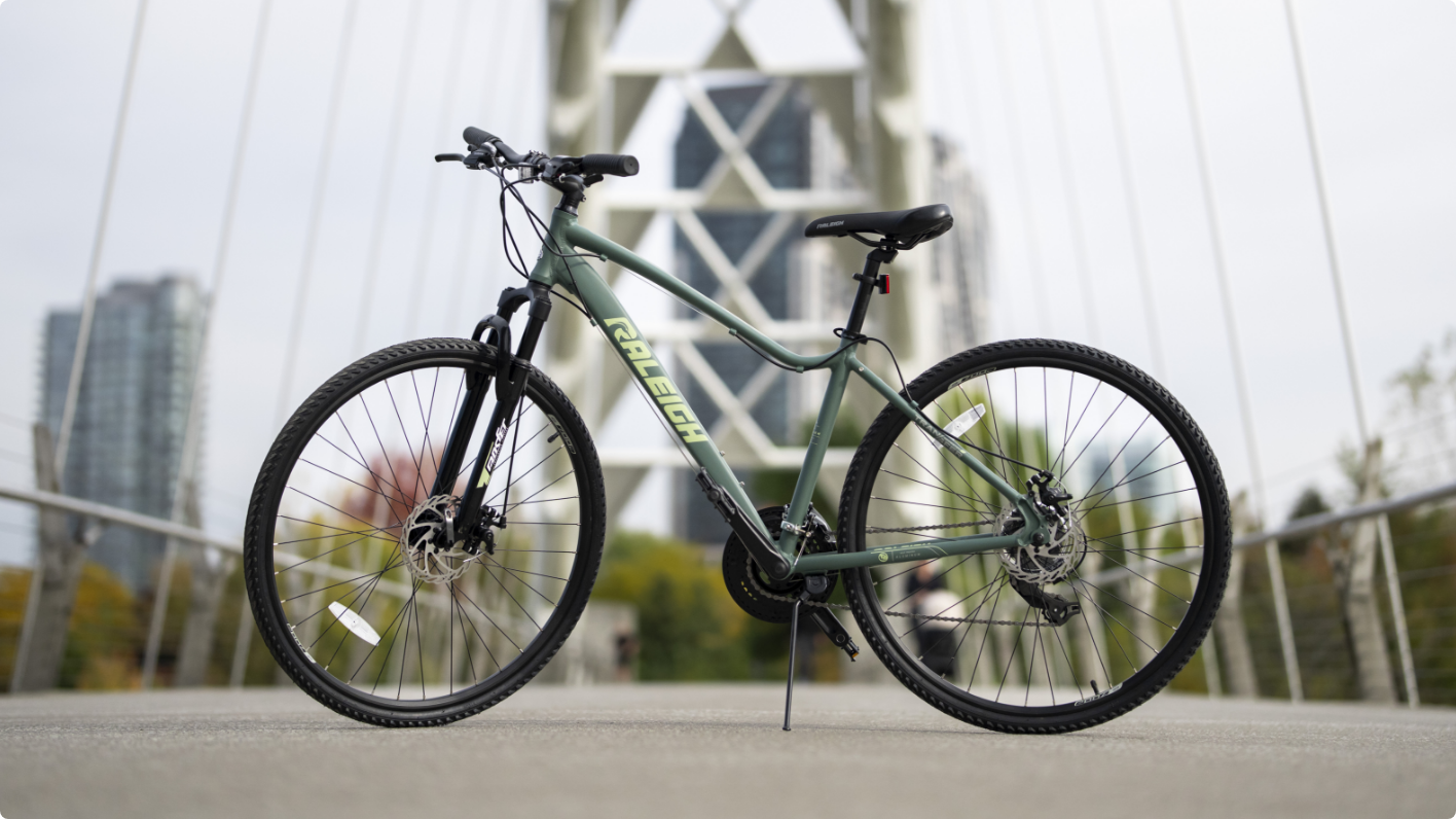 A bicycle parked on a bridge with a cityscape in the background.