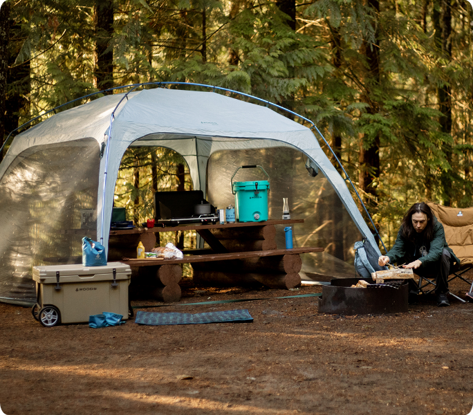 Une présentation d’articles de camping avec une tente et de l’équipement de plein air les bois.