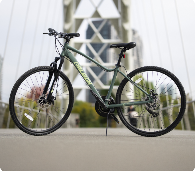 Un vélo stationné sur un pont avec une architecture moderne en arrière-plan.