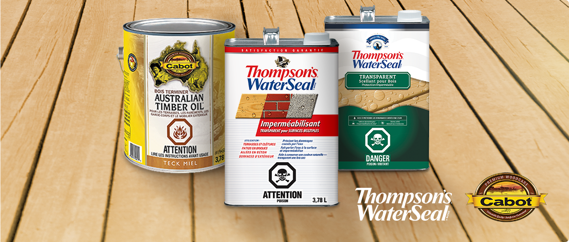 Three cans of wood sealant and timber oil products from Thompson's WaterSeal and Cabot displayed on a wooden surface.