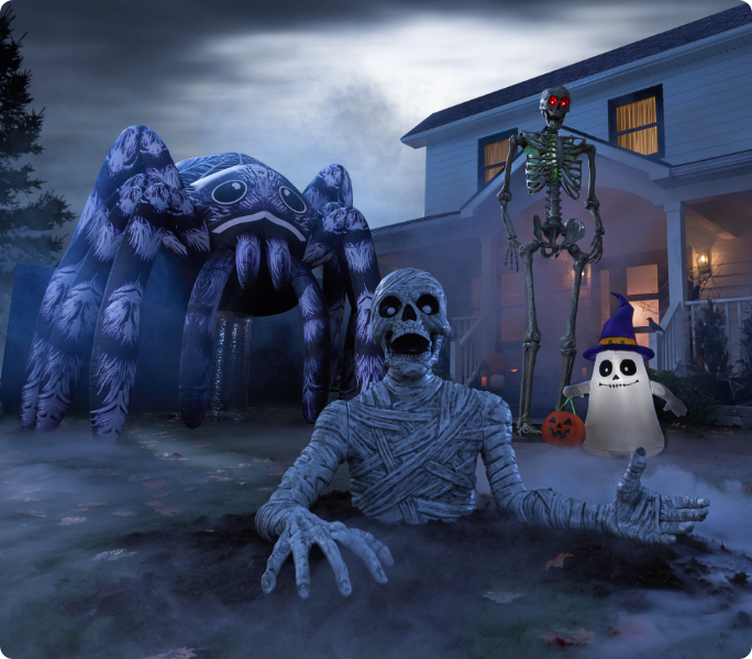 Yard with Halloween inflatables and skeletons at night.
