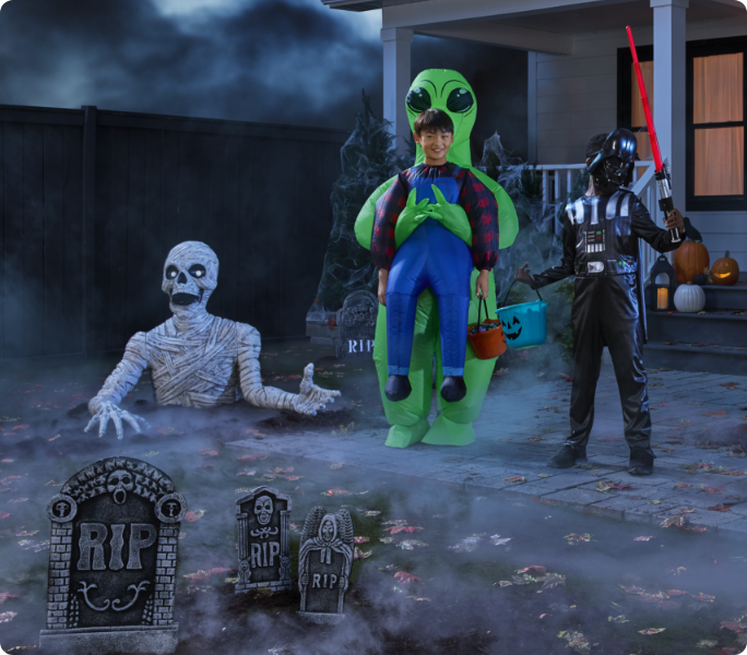 Outdoor scene with inflatables, skeletons and tombstones.