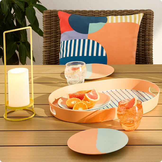 A dining table setup with colourful plates and pillows